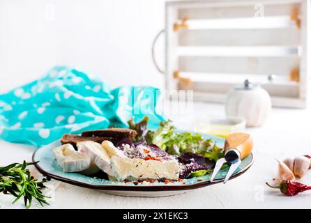 Camambrato, insalata di barbabietole e pane su piatto blu Foto Stock