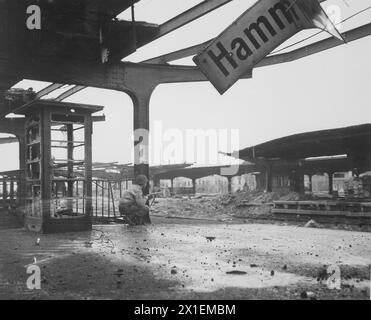 Allerta per il movimento nemico, un privato di prima classe accovacciato con una carabina alla stazione ferroviaria nella città appena catturata di Hamm, Germania ca. 6 aprile 1945 Foto Stock