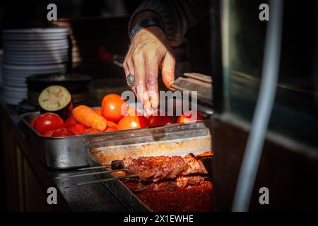 Spolverare spezie sui kebab in un ristorante di Istanbul, Turchia Foto Stock