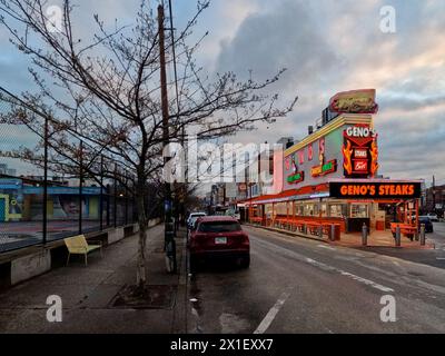 Geno's Steaks, un pilastro del mercato italiano di Filadelfia, si illumina al neon all'alba. Foto Stock