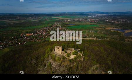 Una vista aerea cattura il castello medievale di Chojnik in cima a una montagna nella catena montuosa di Karkonosze. L'antica fortezza si erge orgogliosamente in mezzo al panoramico lan Foto Stock