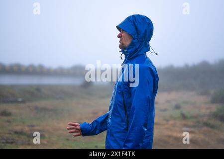 Descrizione: Veduta laterale di un turista deluso che gli tiene la mano sotto la pioggia. 25 Fontes, Isola di Madeira, Portogallo, Europ Foto Stock