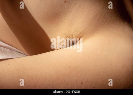 Sfida gli standard di bellezza e celebra l'autenticità naturale con questa immagine potente di un'ascella femminile adornata di capelli Foto Stock