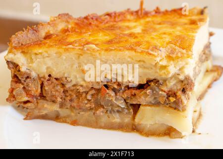 Viziatevi con la ricca tradizione culinaria del Mediterraneo con questo invitante piatto di moussaka. Strati di melanzane teneri, carne macinata salata e c Foto Stock