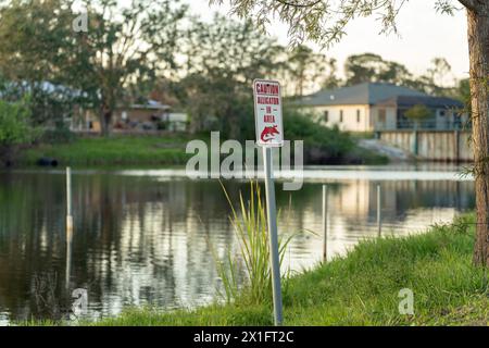 Cartello di avvertenza con alligatore nel parco Florida per informazioni su precauzioni e sicurezza durante le passeggiate vicino all'acqua Foto Stock