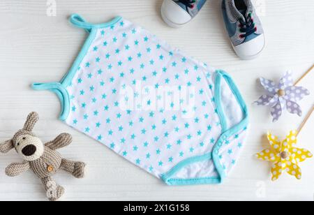 Rompicapo blu con cane giocattolo a maglia, mulini a vento giocattolo e scarpe per bambini. Set di vestiti e accessori per bambini per l'estate. Outfit per bambini alla moda. Piatto, da a. Foto Stock