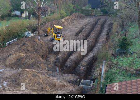 giardino residenziale scavato sul retro con miniescavatore per impianto di riscaldamento a pompa di calore a terra Foto Stock