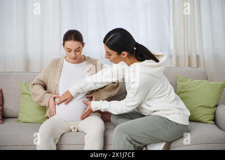 Una donna incinta siede su un divano accanto al suo allenatore durante i corsi per i genitori. Foto Stock