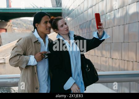 Una coppia felice cattura un momento di selfie mentre esplora la città, godendosi la loro avventura di viaggio insieme Foto Stock
