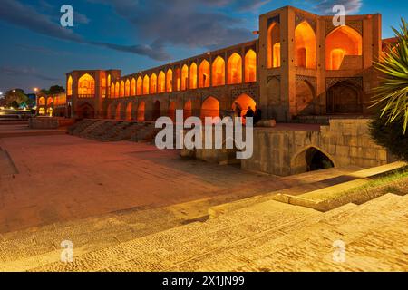 Vista del Ponte Khaju illuminato del XVII secolo sul fiume Zayanderud durante la stagione secca con letto asciutto. Isfahan, Iran. Foto Stock