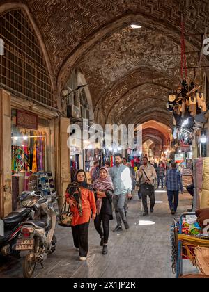 La gente cammina in uno stretto passaggio nel Gran Bazar di Isfahan, Iran. Foto Stock