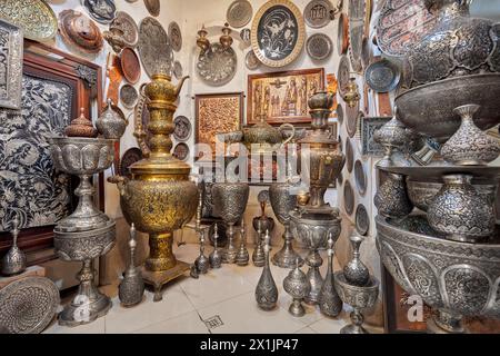 Una selezione di oggetti Qalamzani, o Ghalamzani (arte tradizionale iraniana dell'incisione del metallo) esposti in un negozio di articoli da regalo nel Grand Bazaar. Isfahan, Iran. Foto Stock