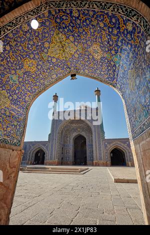 Vista del cortile della Moschea dello Scià (Masjed-e Shah) attraverso un arco con elaborato soffitto piastrellato. Isfahan, Iran. Foto Stock