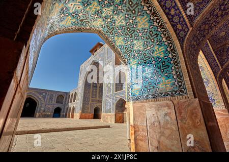 Vista del cortile della Moschea dello Scià (Masjed-e Shah) attraverso un arco con elaborato soffitto piastrellato. Isfahan, Iran. Foto Stock