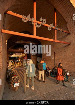 La gente cammina in un passaggio ad arco dal Grand Bazaar a Piazza Naqsh-e Jahan, sito patrimonio dell'umanità dell'UNESCO. Isfahan, Iran. Foto Stock