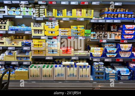 Scaffali nella sezione casearia del supermercato con latte, burro, alcuni formaggi morbidi e bevande a base di latte Foto Stock