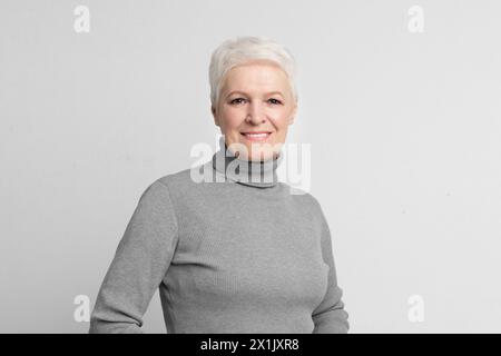 Donna anziana che guarda la macchina fotografica con un sorriso Foto Stock