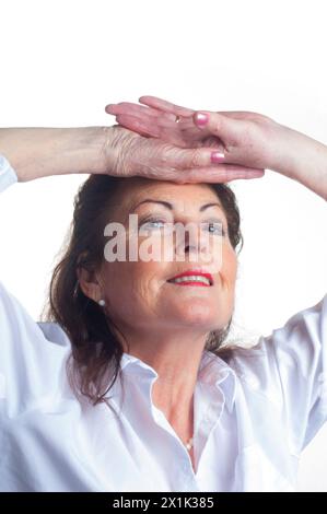 Ripresa in studio di una donna senior espressiva tagliata su sfondo bianco - John Gollop Foto Stock