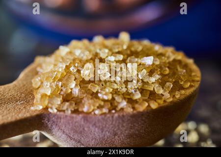 Cristalli di zucchero di canna su cucchiaio di legno - primo piano culinario Macro Foto Stock