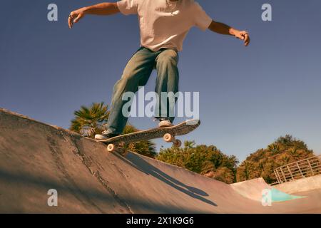 Primo piano di un giovane che fa dei trucchi sul suo skateboard allo skate Park. Concetto di sport attivo Foto Stock