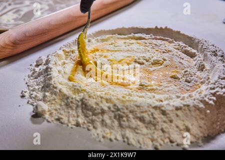 Preparazione della pasta fatta in casa - primo piano farina, uovo e olio d'oliva Foto Stock
