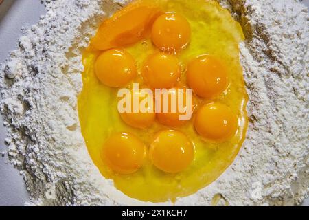 Tuorli d'uovo freschi sulla farina per la preparazione della pasta - Vista dall'alto Foto Stock