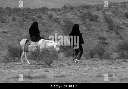 Beduini a cavallo di un asino nel deserto Foto Stock