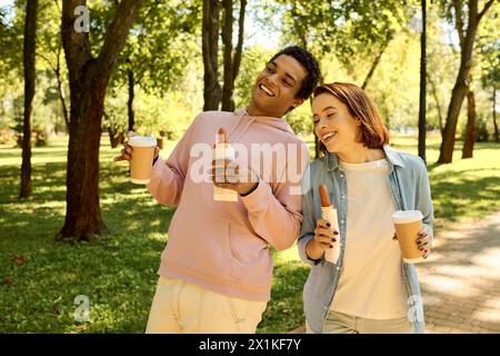 Una coppia varia e amorevole, vestita con abiti vivaci, godetevi una piacevole passeggiata attraverso un lussureggiante parco. Foto Stock