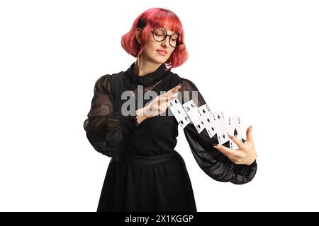 Maga donna che esegue un trucco con carte volanti isolate su sfondo bianco Foto Stock