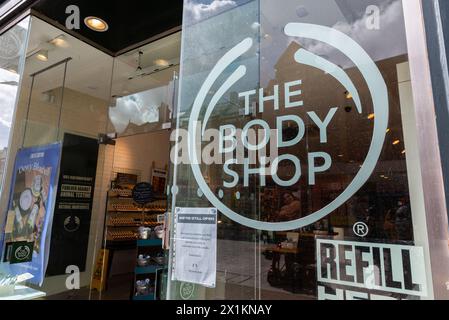 Avviso sulla finestra della filiale Body Shop che informa i clienti che sono ancora aperti nonostante il marchio sia in fase di amministrazione. Siamo ancora aperti Foto Stock