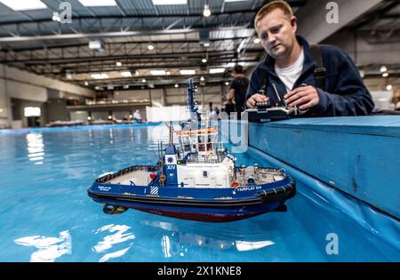 Dortmund, Germania. 17 aprile 2024. Marvin Hans dello Schiffsmodellbau Club di Waltrop controlla un modello di rimorchiatore portuale in un grande bacino d'acqua alla fiera Intermodellbau. La fiera del tempo libero di quattro giorni inizia il 18 aprile. Gli appassionati possono aspettarsi innovazioni in modellini di ferrovie, aeroplani, auto da corsa, macchinari per l'edilizia, camion e navi in miniatura. Crediti: Dieter Menne/dpa/Alamy Live News Foto Stock