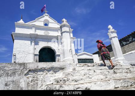 Una donna maya indigena cammina fino alla piccola cappella El Calvario a Chichicastenango, Guatemala. La Chiesa cattolica e le credenze maya si mescolarono molto tempo fa nelle regioni indigene del Guatemala in un processo chiamato sincretismo. Foto Stock