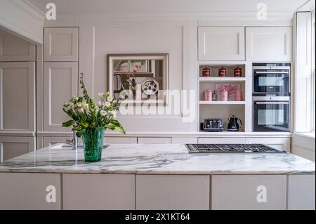 Fiori tagliati su un piano di lavoro in marmo nell'elegante residenza georgiana di Greenwich, Londra, Regno Unito Foto Stock