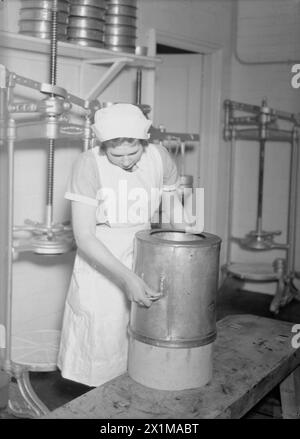 ADDESTRAMENTO DELL'ESERCITO DI TERRA FEMMINILE, PROBABILMENTE A CANNINGTON FARM, SOMERSET, INGHILTERRA, C 1940 - Un membro dell'Esercito di terra femminile produce formaggio, probabilmente presso il centro di addestramento WLA a Cannington, c 1940, Foto Stock