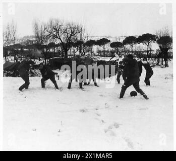 Gli uomini del 230/58 Medium Regiment, British Army, si impegnano in una battaglia con palla di neve sul fronte italiano, influenzando le operazioni di prima linea. Foto Stock