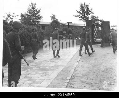 IL GOVERNO TEDESCO VIENE ARRESTATO - prigionieri che vengono portati nel cortile dopo essere stati perquisiti, British Army, 21st Army Group Foto Stock