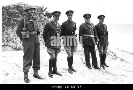 IL RE VISITA EAST COAST - il re con gli ufficiali sulla riva del mare mentre ispeziona le difese a Palling con il generale Lieut Osborne, EA..DSO., e il maggiore generale M.E. Beckwith-Smith, British Army Foto Stock