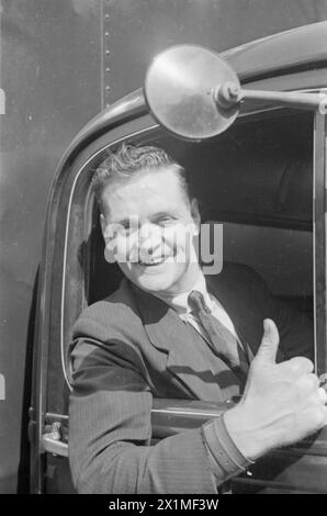 PERSONE AL LAVORO IN TEMPO DI GUERRA: VITA QUOTIDIANA IN TEMPO DI GUERRA GRAN BRETAGNA, 1940 - Un camionista sorridente dà un cartello con il pollice dal taxi del suo veicolo, da qualche parte in Gran Bretagna, 1940, Foto Stock