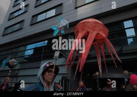 Londra, Inghilterra, Regno Unito. 17 aprile 2024. Ocean Rebellion (OR) organizza un concerto di protesta contro una cima mineraria in alto mare all'Hilton di Canary Wharf, evidenziando i suoi effetti dannosi sulla vita marina. Si ritiene che l'estrazione di˜noduli di manganese dai fondali marini per l'uso nelle tecnologie verdi provochi notevoli danni ambientali. Si schiaccia il fondale marino della vita, rilascia pennacchi di sedimenti e crea rumore che disorienta gli animali marini. L'inquinamento acustico causato dalle miniere d'altura è centinaia di volte più forte di un lancio di razzi spaziali. Un pidocchio da miniera d'altura Foto Stock