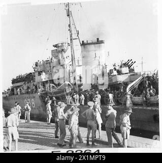 ARRIVO DELLE TRUPPE EVACUATE DA CRETA - truppe coloniali che osservano una delle navi da guerra che si legano alla banchina all'arrivo in un porto egiziano, l'esercito britannico Foto Stock