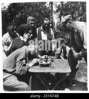 Una FAMIGLIA FRANCESE TORNA AL SUO VILLAGGIO DISTRUTTO DALLE CONCHIGLIE - ora che il wireless sta funzionando, la famiglia si riunisce intorno ad esso per ascoltare gli ultimi bollettini di notizie, British Army, 21st Army Group Foto Stock