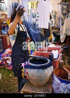 Un panno di tintura femminile per il viso non riconosciuto con colorante indaco. metodo tradizionale di lavorazione del tessuto di ammollo, prodotto artigianale artigianale, artigianale, maglietta, piccola Foto Stock