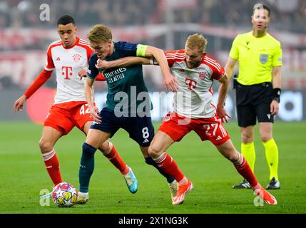 Martin Odegaard dell'Arsenal (centro a sinistra) combatte per il pallone con Jamal Musiala del Bayern Monaco e Konrad Laimer durante i quarti di finale della UEFA Champions League, partita di andata e ritorno all'Allianz Arena di Monaco. Data foto: Mercoledì 17 aprile 2024. Foto Stock