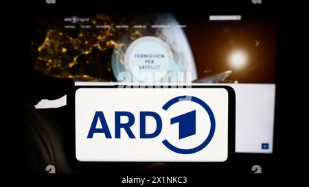 Persona che detiene un cellulare con il logo dell’organismo tedesco di radiodiffusione pubblica ARD davanti alla pagina web. Mettere a fuoco il display del telefono. Foto Stock