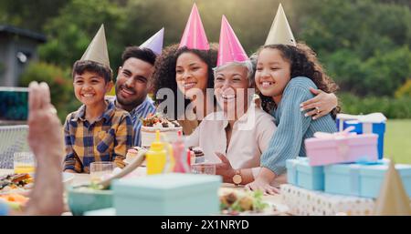 Senior, coppia e felice con la fotografia alla festa di compleanno per festeggiare, ridere e ricordi in giardino. Famiglia, persone e bambini con Foto Stock