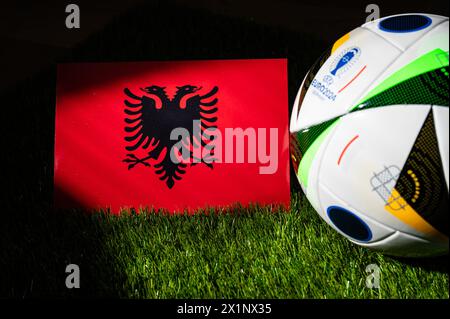 LIPSIA, GERMANIA, 17 APRILE 2024: Bandiera nazionale albanese e pallone ufficiale di calcio del torneo di calcio Euro 2024 in Germania piazzato su erba verde. BL Foto Stock