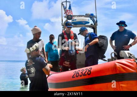 Woleai, Micronesia, Stati Federati di. 12 aprile 2024. L'equipaggio del cutter di pronto intervento classe Sentinel USCGC Oliver Henry carica un bambino di 9 anni ferito per essere trasferito in un ospedale durante una visita per assistere i residenti della remota isola, il 12 aprile 2024 a Woleai, Stato di Yap, Stati Federati di Micronesia. Crediti: CWO Sara Muir/USCG/Alamy Live News Foto Stock