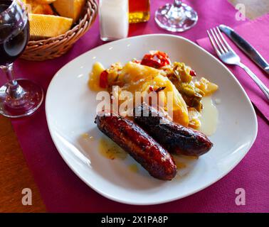 Salsicce alla griglia con patate bollite e pepe Foto Stock