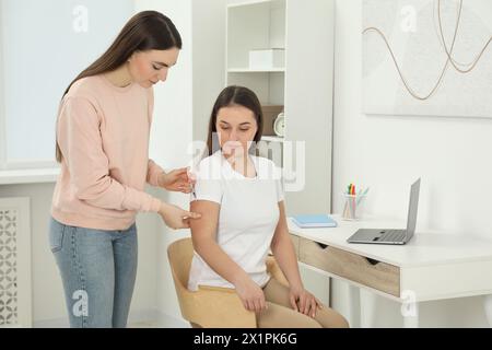 Donna che fa l'iniezione di insulina al suo amico diabetico a casa Foto Stock