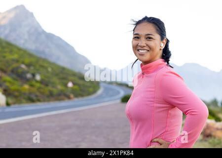 Escursionista birazziale in piedi sulla strada di montagna, con la cima rosa, spazio per copiare Foto Stock